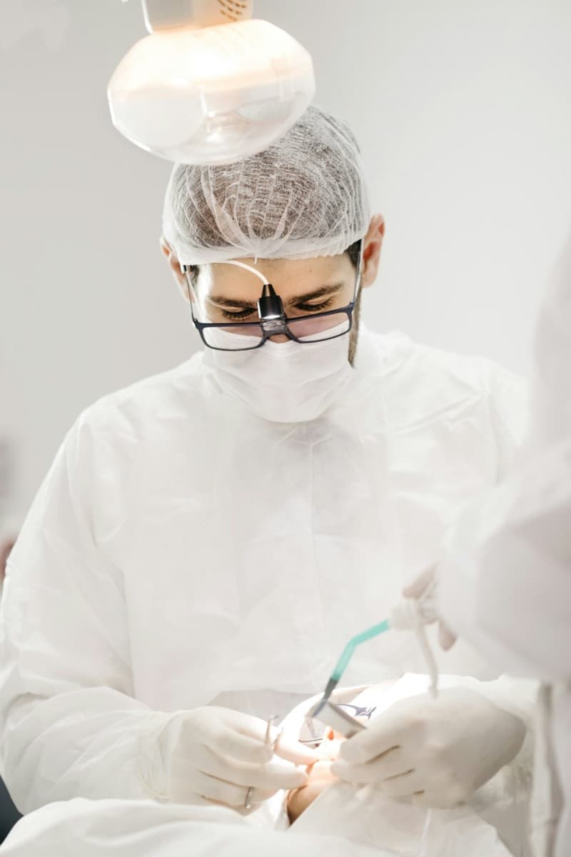 Cirujano dental realizando un procedimiento con equipo estéril