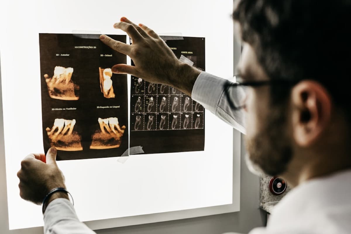 Odontólogo analizando radiografías de raíces dentales